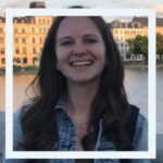 Photo of person smiling in front of river and buildings