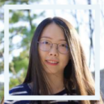 Person with glasses standing in front of trees